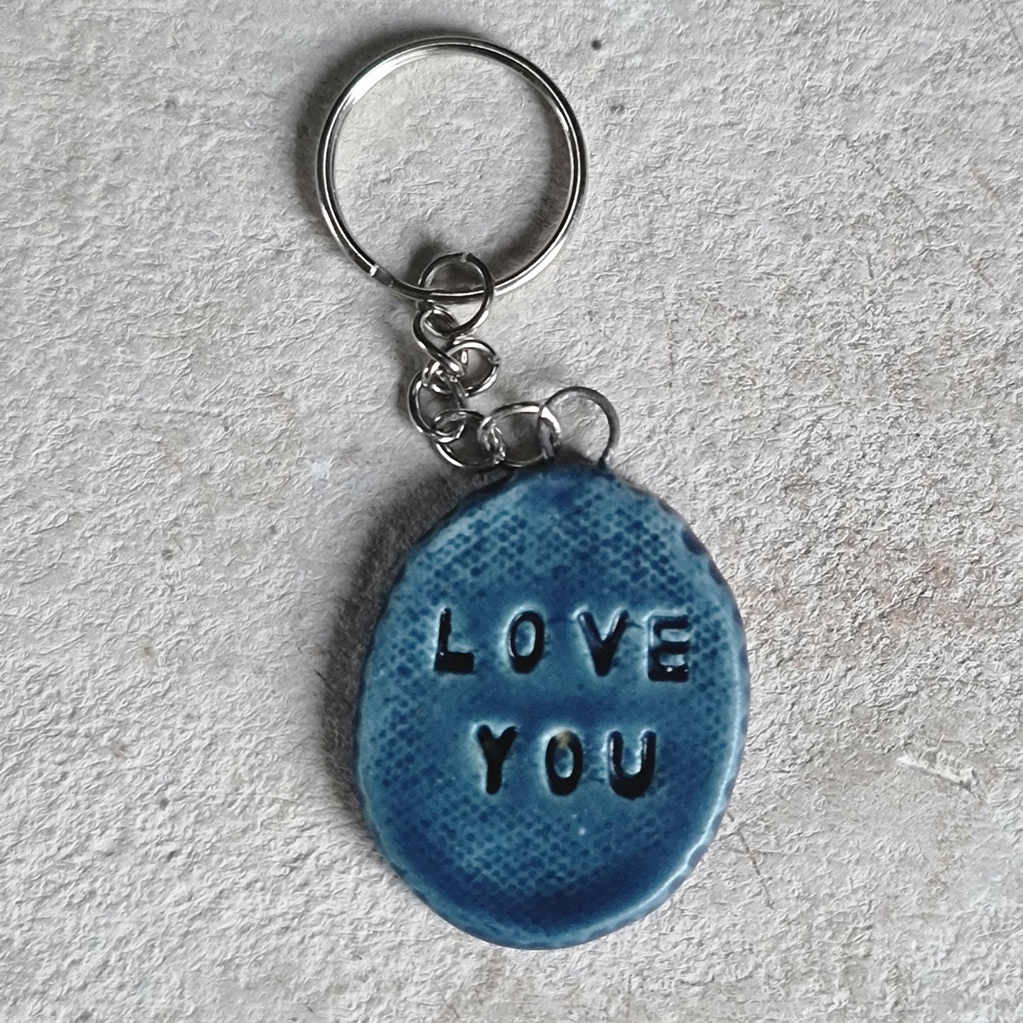 handcrafted oval ceramic key rings with embossed words LOVE YOU