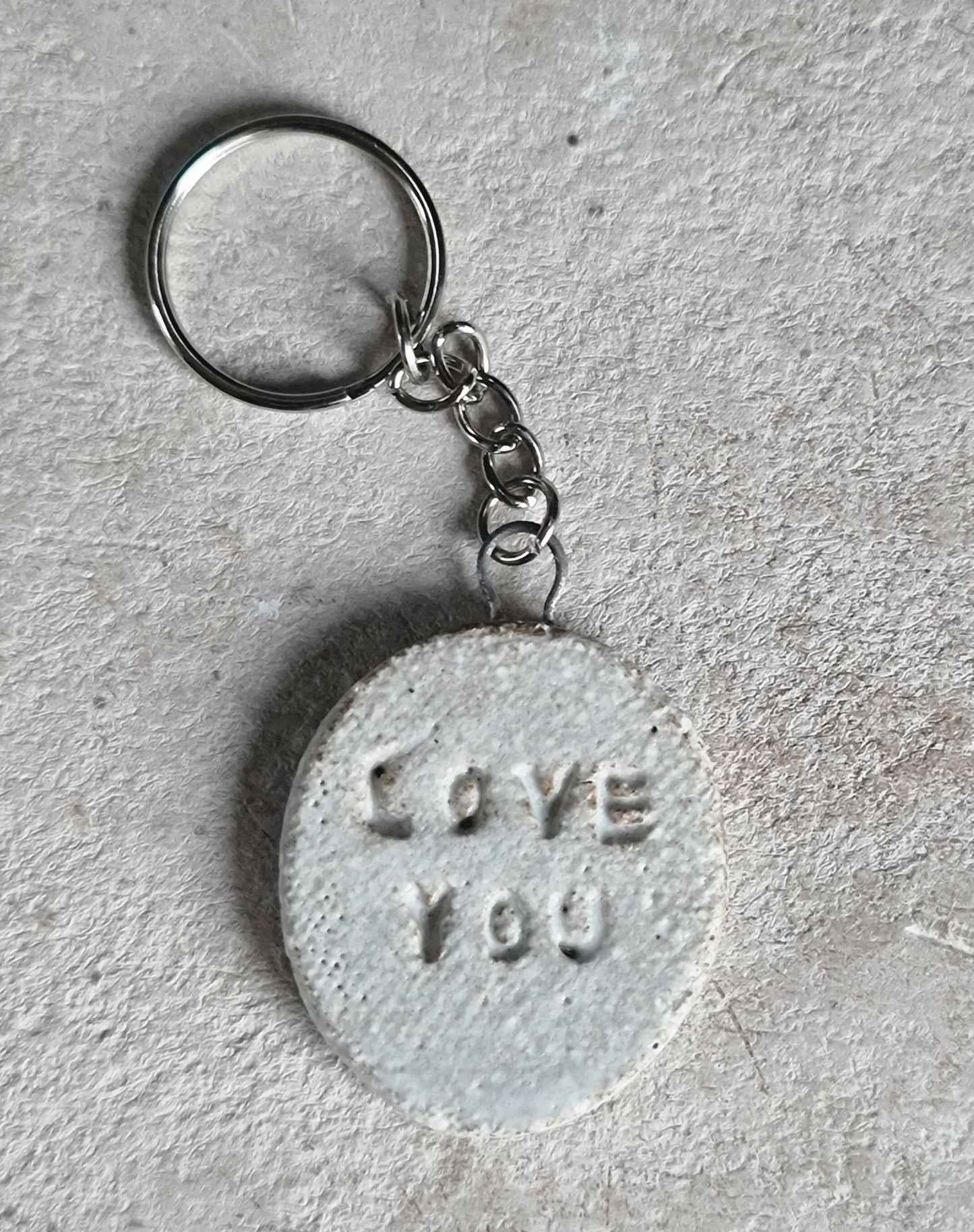 handcrafted oval ceramic key rings with embossed words LOVE YOU