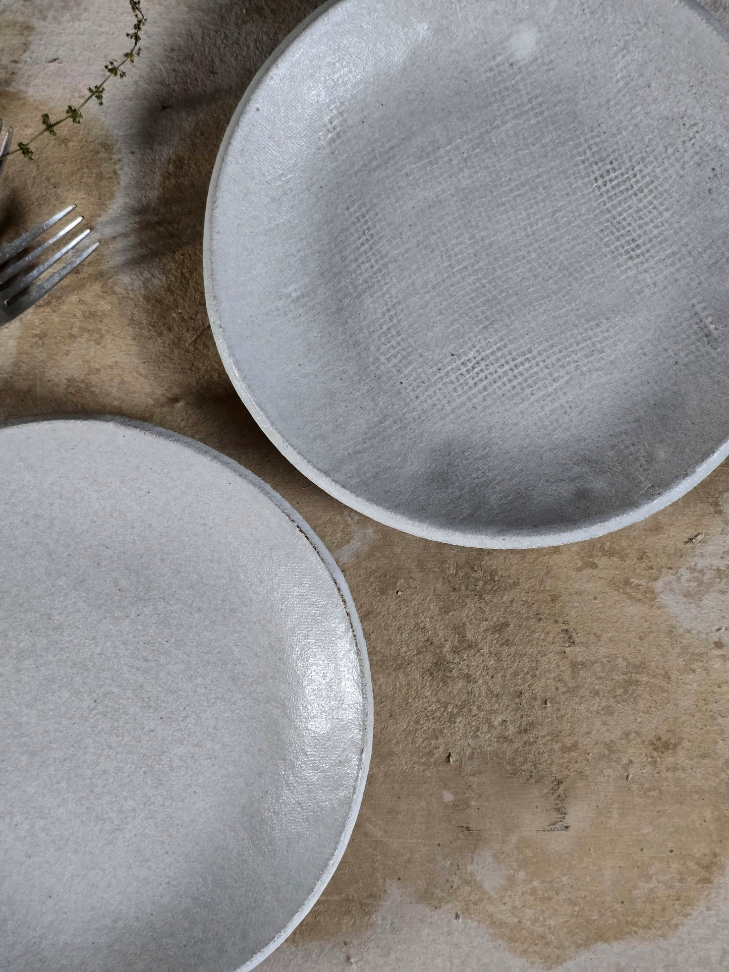 a set of 2 sheer white, soft grey round dinner plates