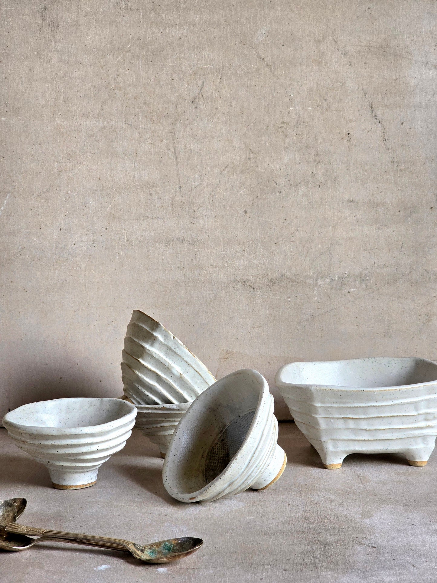 organically shaped creamy white bowls and a squarish shape vessel